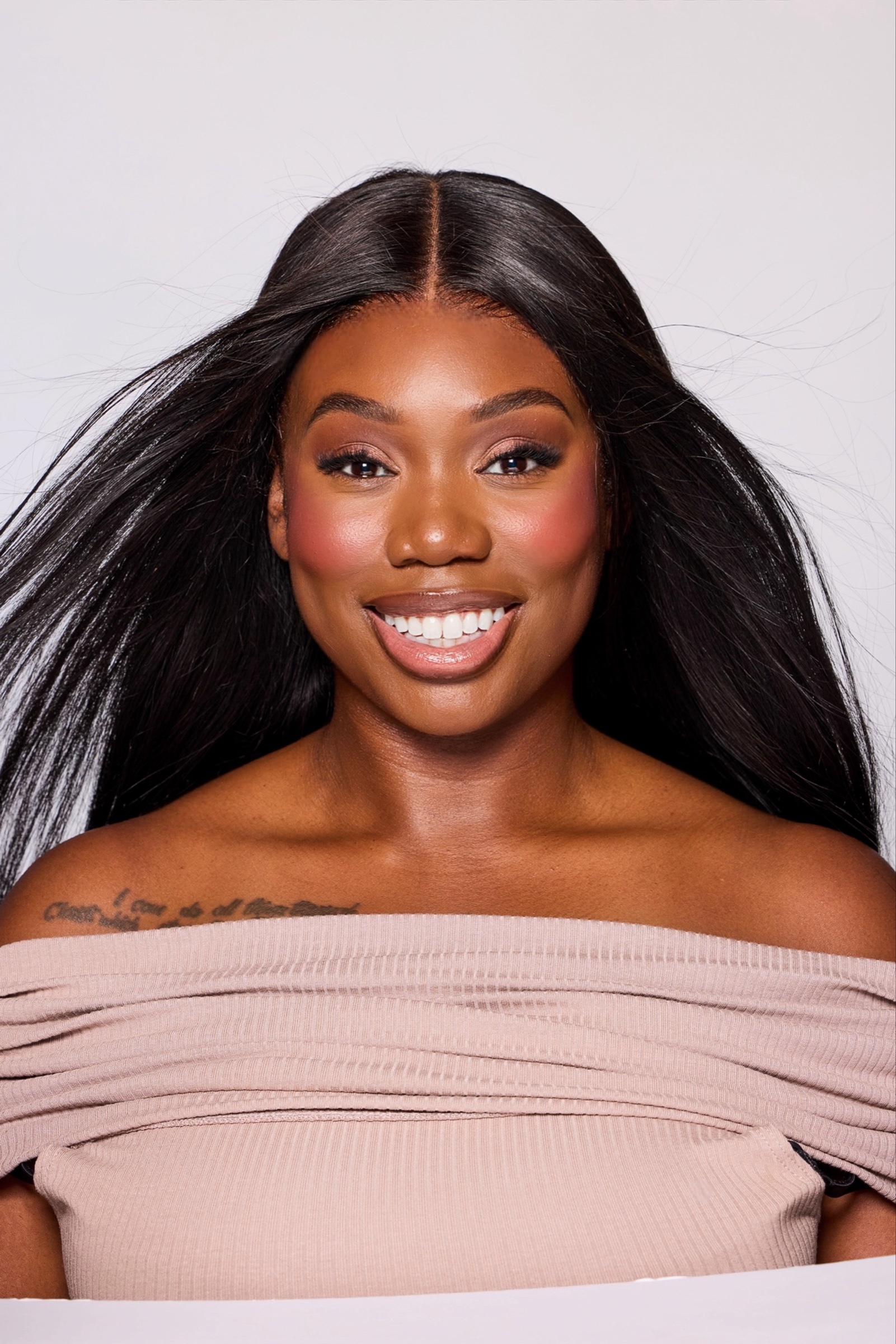 Mara smiling in a polished beauty portrait